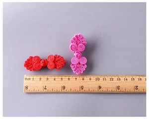 Dettaglio di fermagli per capelli in stile nodo cinese in tessuto rosso e rosa
