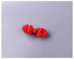 Dettaglio di un fermaglio per capelli a nodo cinese rosso con corda intrecciata e perle