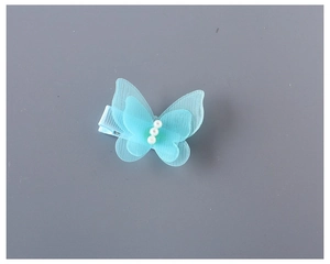 Détail de la pince à cheveux papillon bleu clair en résille avec trois perles