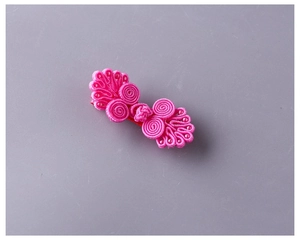 Dettaglio del fermaglio per capelli a nodo cinese rosa fucsia con perline e finitura satin