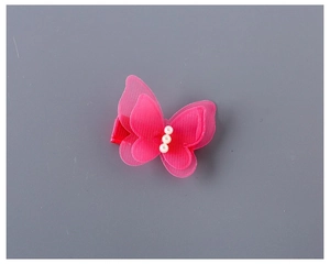 Détail d'une barrette papillon rouge rose avec maille double couche et trois perles blanches