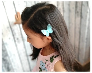 Gros plan d'un enfant portant une pince à cheveux papillon en tulle bleu clair et perle