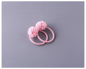 Détail de deux chouchous boules de fleurs en tulle rose faits main pour filles élastiques