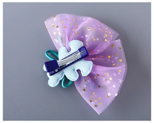 Détail de pince à cheveux enfant en tulle violet avec sequins étoiles et clip en métal