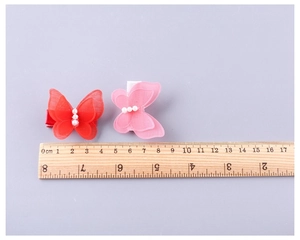 Détail de barrettes papillon en gaze avec perles, mesurant environ 4,5 à 5,0 cm de large