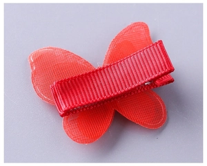 Détail de l'arrière de la barrette papillon rouge en tulle avec ruban protecteur