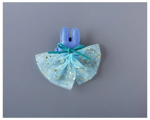 Détail d'une pince à cheveux lapin bleu avec nœud en velours vert et tulle à étoiles