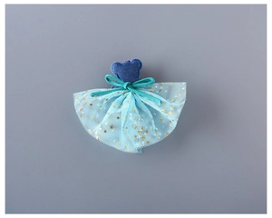 Détail de la pince ours en denim avec nœud en velours et jupe en tulle pailletée