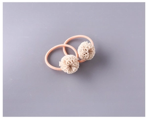 Détail de deux chouchous faits main avec boules de fleurs en dentelle rose et beige