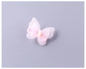 Détail de la pince à cheveux papillon en tulle rose avec trois perles pour fillettes