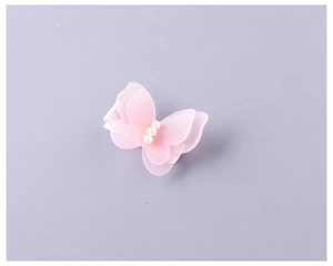 Détails d'une pince à cheveux papillon rose en tulle avec perles et ruban satiné