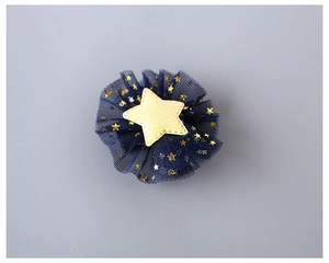 Close-up of handmade navy mesh hair clip with golden sequin stars for girls