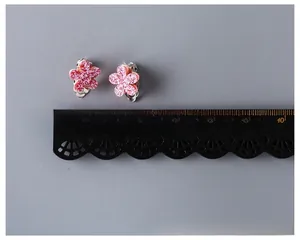 Close-up of pink glitter flower clip-on earrings for girls with silver metal backs