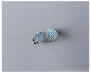 Close-up of glittery sky blue heart-shaped clip-on earrings for kids with silver clips