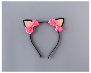 Detail eines süßen Katzenohren-Stirnbands mit rosa Glitzer und Satinschleifen