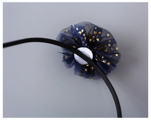 Detail showing back construction of navy mesh flower headband with golden stars