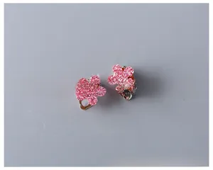 Macro shot of glittery pink flower clip-on earrings for girls with shimmering texture