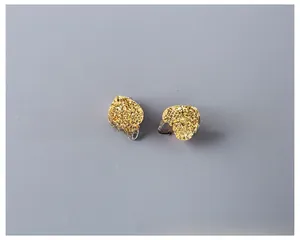 Detailed view of children heart ear clips with gold glitter texture and clip-on back