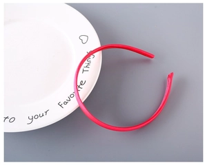 Detailed close-up of a vibrant red fabric-covered headband placed on a ceramic plate