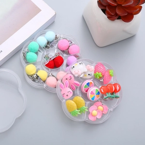 Detail view of colorful resin fruit and flower clip-on earrings in flower storage boxes