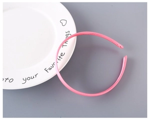 Detail of pink fabric-covered narrow 1cm headband placed on decorative ceramic plate