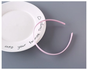 Close-up of pink 1cm fabric wrapped headband with fine stitching on ceramic plate