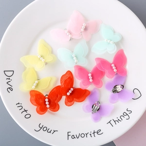 Detail of colorful layered tulle butterfly hair clips with white pearls and metal back clips