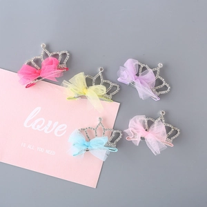 Detail of five colorful glitter crown hair clips with rhinestones and mesh bows