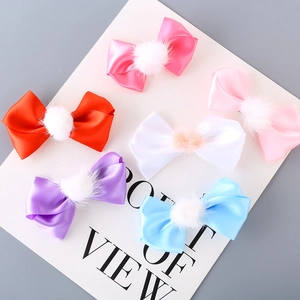 Detail showing 6-piece satin ribbon bow hair clips with soft fur pom-poms in various colors