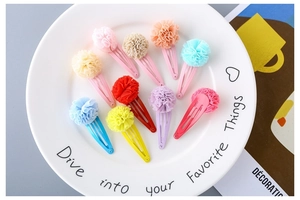 Set of ten colorful mesh flower hair clips for girls displayed on a white plate