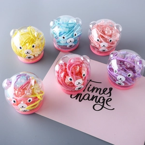 Détail de 6 pots en forme d'ours avec élastiques colorés et perles pailletées pour filles