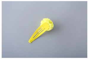 Close-up of bright yellow fabric flower on a matching metal snap hair clip for kids