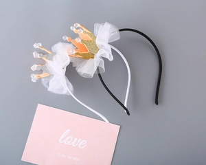 Close-up of glittery gold and silver princess crowns on mesh hairbands for girls