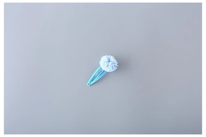 Detailed close-up of a blue chiffon flower hair clip with a classic metal snap base