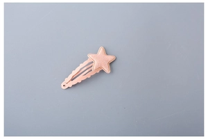 Close-up of a pink star hair clip with glitter texture and detailed stitching details