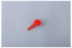 Detail view of a red fabric flower petal design on a durable metal snap hair clip for girls