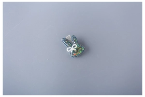 Detailed view of kids rabbit hair clip with blue glitter and pearl bow decoration