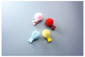 Détail de barrettes à pompons en tulle coloré pour filles sur fond bleu plat