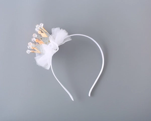 Close-up of sparkling crown headband with white tulle bow and glitter for girls