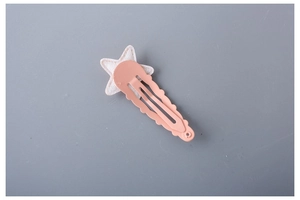 Detail showing wave-shaped pink hair clip with a cream textured star for girls