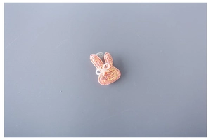 Detailed view of pink glitter bunny hair clip with pearl bow and silver metal clip