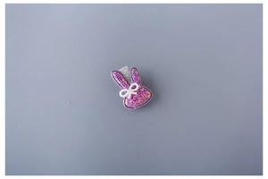 Detail of cute purple glitter bunny hair clip with pearl bow and sparkly sequins
