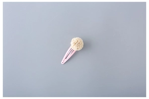 Detail of pink metal BB hair clip with a soft beige pleated fabric flower ornament