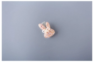 Close-up of glitter bunny hair clip with pearl bow detail and silver metal alligator grip