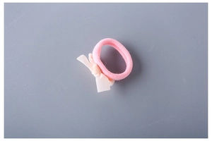 Close-up of pink elastic hair tie with a small cream-white ribbon bow detail