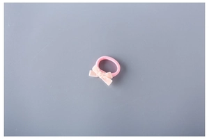 Close-up of pink elastic hair tie with a delicate bow design for kids and girls