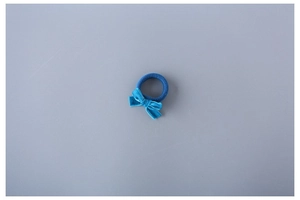 Detailed view of a blue velvet bow elastic hair tie with a soft texture on a grey background