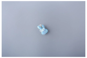 Detailed view of light blue glitter bunny hair clip with pearl neck and metal base