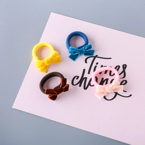 Four-piece velvet bow hair tie set in vibrant colors on a pink presentation card