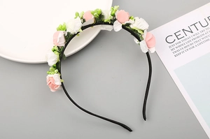 Dettaglio del cerchietto con rose di schiuma rosa e bianche e piccoli boccioli verdi